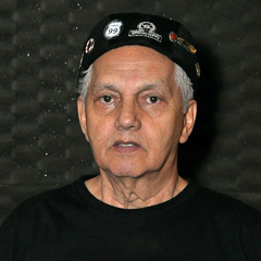OSEAS RODRIGUES - Líder Vocal - Um dos fundadores da banda Porão 99, onde permaneceu até 1990. Reconhecido como um dos melhores vocalistas de sua época, interpretando clássicos do rock de bandas como Deep Purple, Led Zeppelin, Pink Floyd, Queen, Black Sabbath, Alice Cooper, entre outros. Sua versatilidade em adotar diferentes estilos musicais conectava o público a memórias e emoções únicas, algo que só um grande músico e a música podem alcançar.